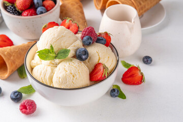 White ice cream bowl with vanilla gelato and fresh berries
