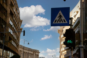 City street at dusk with silhouette of buildings and traffic signs under clear sky near pedestrian crossing