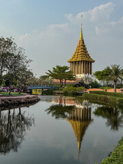 Naklejka premium Golden temple stands majestically by the calm pond in a scenic landscape