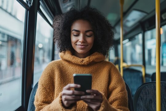 Young black woman using smartphone on bus during commute