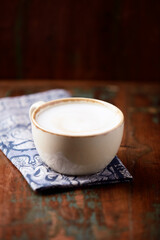 Cappuccino on dark wooden background. Soft focus. Close up.