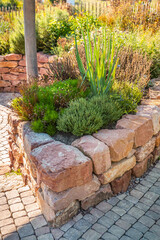 Obraz premium A modern vegetable garden with raised bricks beds. Raised beds gardening in urban garden growing plants and vegetables