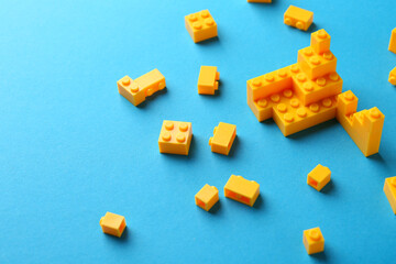 Constructor toy. Many yellow building blocks on light blue background, space for text