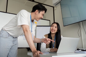 Obraz premium Colleagues discussing financial strategies while reviewing data on a laptop in a meeting.