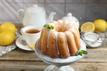 Tasty lemon cake with glaze and mint on wooden table, closeup