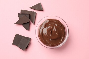 Delicious chocolate mousse in glass bowl on pink background, top view