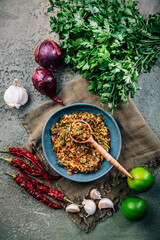 Homemade chimichurri paste with ingredients in a bowl