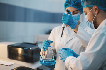 team of doctors man and woman in protective medical clothing working in a modern medical...
