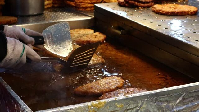 Making bindae-tteok, a traditional Korean food, at the food corner of the market.한국의 전통음식인 빈대떡을 시장의 음식코너에서 만들고있습니다.