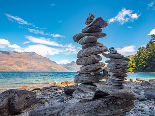 Cairns, New Zealand stacked rocks. lake and mountains in the background