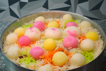 Mutanjan sweet colored rice with cham cham and rasgulla colorful balls, almonds, marmalade, prepared for serving as niyaz. Close-up of a traditional festive sweet dish in India, Pakistan, Bangladesh.