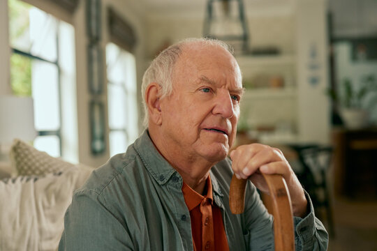 Close up face of thoughtful senior man holding walking cane