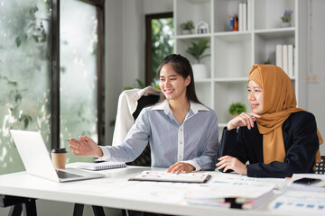 Finance professionals reviewing data on a laptop and discussing strategies in the office.