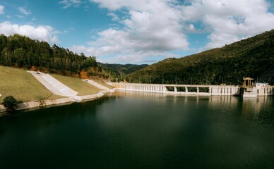 Fototapeta premium Scenic Dam with Lush Green Hills