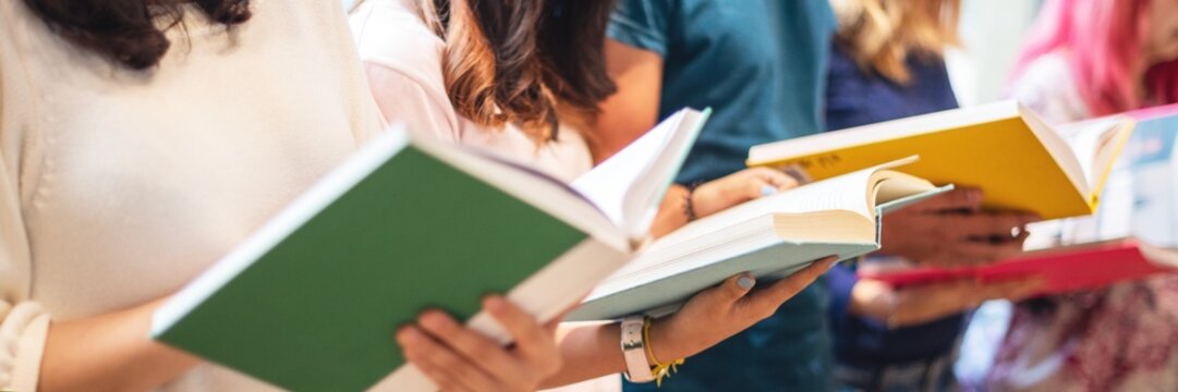 Group of people reading books. Diverse group, reading together. Books in hands, focus on reading. Engaged readers, diverse group, enjoying books. Young people reading books in a row. - Powered by Adobe