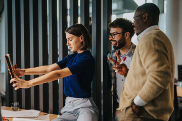Multicultural colleagues engaged in a productive brainstorming session, collaborating and strategizing for success. The team analyzes proposals and shares creative ideas in a modern office environment