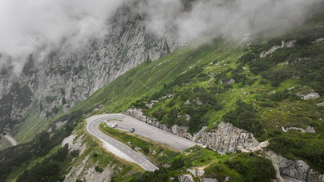 Scenic winding road in Gadmen Switzerland with lush green hills and misty mountains