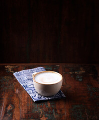 Cappuccino on dark wooden background. Soft focus. Copy space.