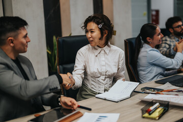Multicultural group of business people engaged in a brainstorming session, sharing ideas and project strategies in a modern office setting. The focus is on teamwork and collaboration for growth.
