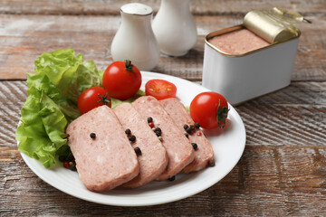 Tasty canned meat, tomatoes, lettuce and spices on wooden table, closeup