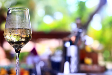a glass of white wine served in a restaurant, abstract background of a summer restaurant
