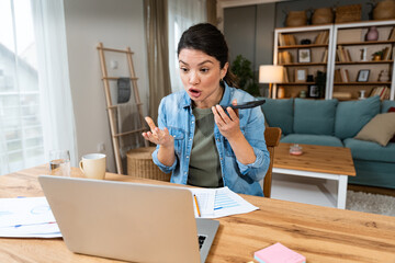 Young angry stressed business woman working from home on laptop computer, having issues with client...