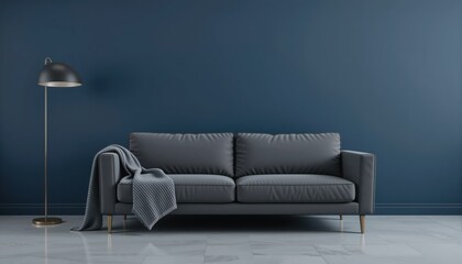 A modern living space showcases a sleek grey sofa paired with a soft throw blanket draped casually. A chic lamp stands beside the couch, illuminating the deep blue wall, creating a tranquil ambiance