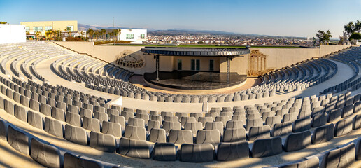 Empty public open air amphitheater on a hill with panorama of town and mountains in the background....