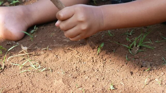 close up of boy's hand playing on the ground. boy playing in the outdoors