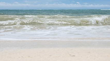 BALI, INDONESIA - JANUARY 22, 2018: Clean sand of Pandava Beach and breaking Indian Ocean waves, Bali.