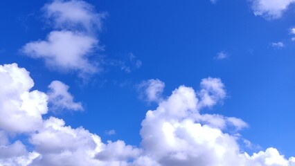 Stunning vibrant blue sky canvas adorned with fluffy white cumulus clouds. Perfect for backgrounds,...