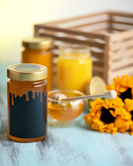 Liquid amber honey in sealed glass containers. Honey jars and glass bowl with honey dipper. Organic homemade product. Healthy crafting food. Nutrition and Food concept. Ready to eat. Copy space.