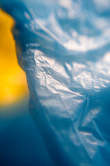 Detalle de arrugas en superficie de plástico azul  sobre fondo amarillo