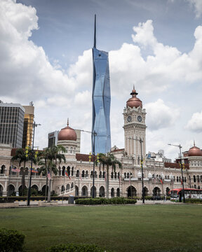 Kuala Lumpur, Malaysia - 27 April 2023: View of Merdeka 118 skyscraper and Sultan Abdul Samad building with palm trees under a cloudy sky, Kuala Lumpur, Malaysia.