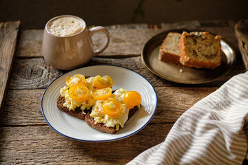 rye bread toast with scrambled eggs and yellow cherry tomatoes