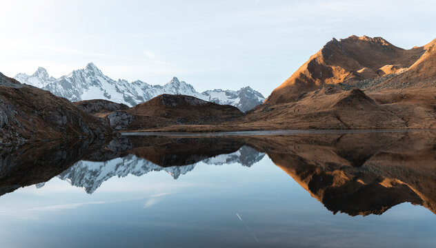 View of serene Lacs de Fenetre with autumn reflection and majestic mountains, La Fouly, Switzerland.