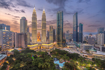View of beautiful cityscape with Petronas Towers and modern skyscrapers at night, Kuala Lumpur, Malaysia.