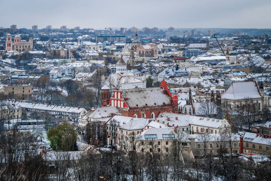 View of snowy cityscape with St. Anne Church, Ortodox Cathedral of the Theotokos, St. Nicholas Church, and Church of St. Casimir, Vilnius, Lithuania.