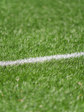 Close up of green grass soccer field with white line marking