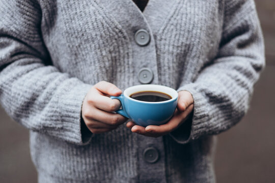 Cozy moment with a coffee in a sweater clad embrace