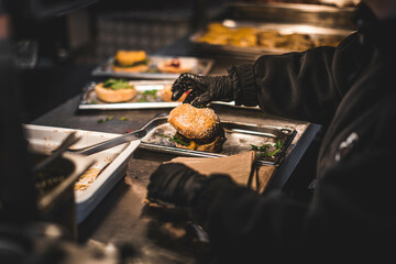 Juicy burgers and sizzling meat on a smoky grill at a vibrant outdoor food festival