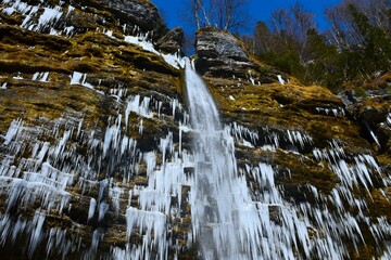 View of Peričnik waterfall with icicles covering the rock cliff in Gorenjska, Slovenia