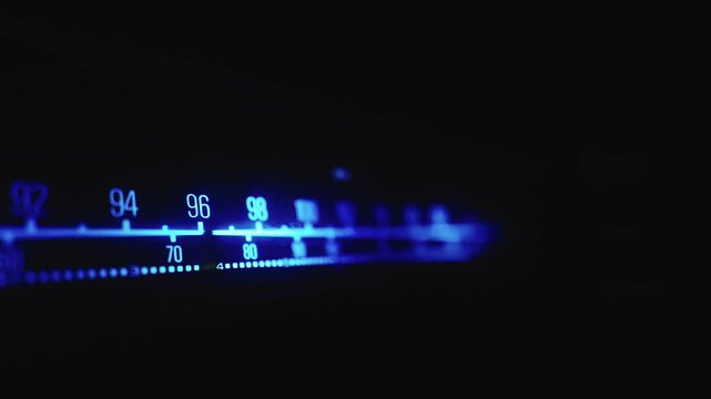 Blue illuminated radiogram tuning frequency dial in dark room CLOSE-UP SLIDE