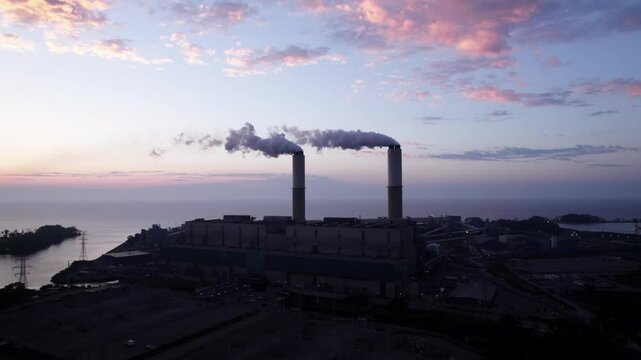 Establishing drone shot of Monroe Power Plant at sunrise with Lake Erie in Monroe, Michigan, USA