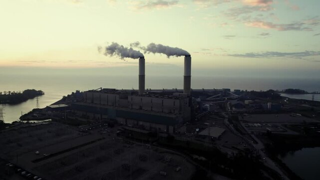 Orbit drone shot of Monroe Power Plant and Lake Erie at sunrise in Monroe, Michigan, USA