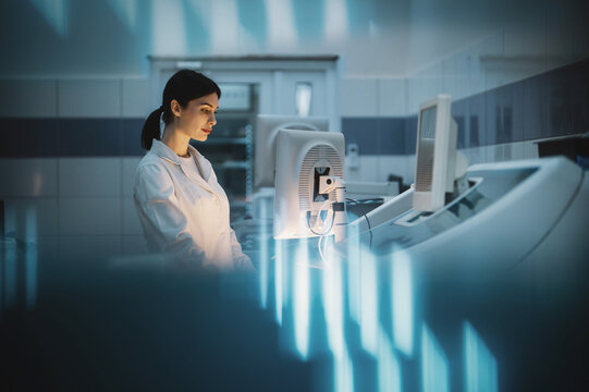 woman working in modern medical laboratory at night on computer, cinematic light