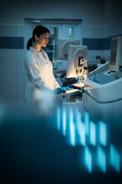 woman working in modern medical laboratory at night on computer, cinematic light