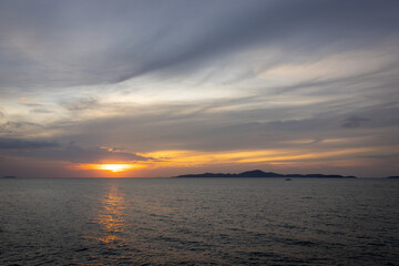 Obraz premium A serene seascape with a distant island silhouetted against the twilight sky