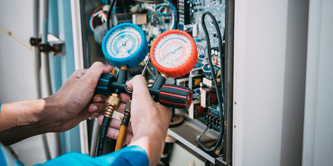 Technician is checking air conditioner refrigerant leak.