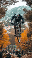 Naklejka premium Soaring High: A daring mountain biker takes flight on a challenging dirt track. The biker is captured mid-air, showing the thrill and risk-taking that come with this extreme sport.